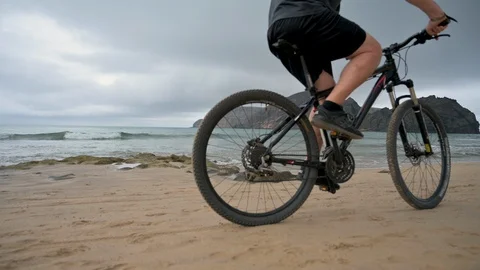 Close up of bicycle passing camera over looking a beach Stock Footage 114503103