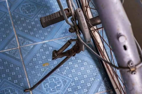 Close-up of a bicycle stand on blue patterned floor tiles Stock Photos