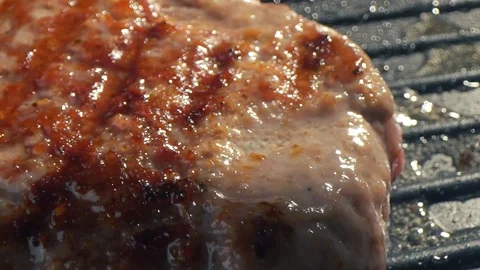 Close-up big beef cutlet is grilled, the chef presses the cutlet with an iron Stock Footage 115775083