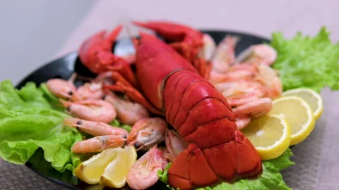 Close-up of a big cooked red lobster on crushed ice with lemon, lime on the side Stock-Footage 302080330