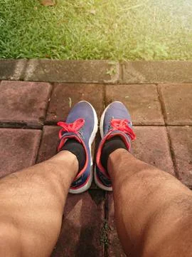 Close up, Big Man Leg Using Blue Sport Shoes, with lens or sun shine flare Stock Photos