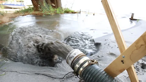 Close-up big pipe of power pump machine pouring mud sludge waste water with sand Stock Footage 148544207