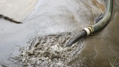 Close-up big pipe of power pump machine pouring mud sludge waste water with sand Stock Footage 148629588