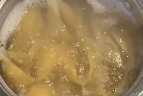 Close-up of big shell pasta In boiling hot water in steel pan. preparation Stock Footage 229834262
