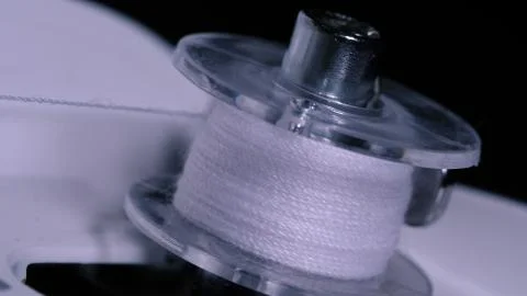 Close up of big spool with thin white thread on working professional sewing Foto stock