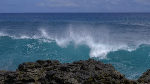 CLOSE UP: Big waves crash into the black volcanic rocks on the remote shore. Stock Footage 111343291