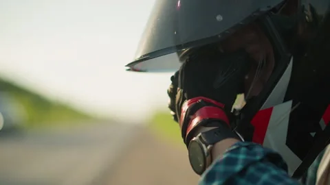 Close-Up of Biker Covering Face Through Helmet Visor on Quiet Rural Road Видео 285628294