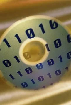 Close up of binary code superimposed over a compact disc Stock Photos