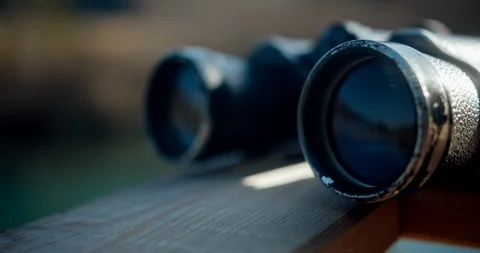 Close up of a binocular front element reflecting a beautiful lake in nature Video stock 129390085
