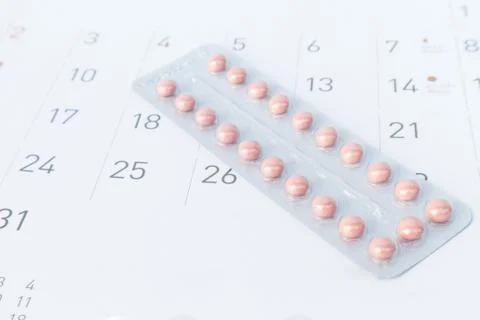 Close up birth-control pill with date of calendar background, health care and Stock Photos