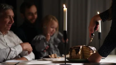 Close-up of a birthday cake being sliced in the foreground Stock Footage 340063525
