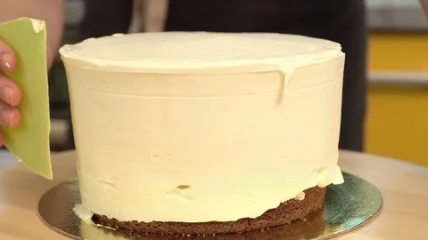 Close-up: biscuit cream in the form of a spiral on the cake. Chocolate sponge Stock Footage 87049522