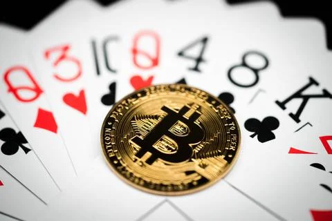 Close-up of a bitcoin coin on a deck of playing cards. Stock Photos