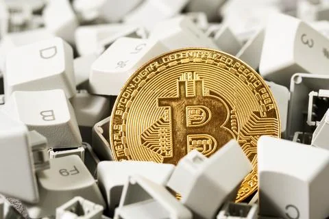 Close-up of bitcoin coin in a pile of computer keyboard buttons Stock Photos