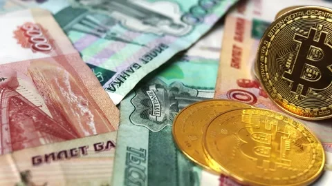 A close-up of Bitcoin coins laying on Russian rubles banknotes Stock Footage 281290853