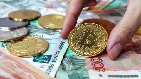 A close-up of Bitcoin coins laying on Russian rubles banknotes Stock Footage 281494741