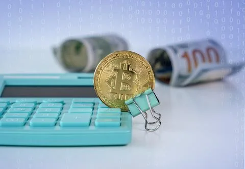 A close up of bitcoin coins stacked on a document with a calculator and pen.. Stock Photos