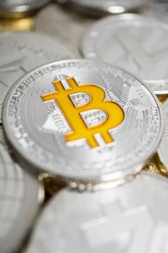 Close-up of bitcoin physical coin on stack of many other cryptocurrencies Stock Photos