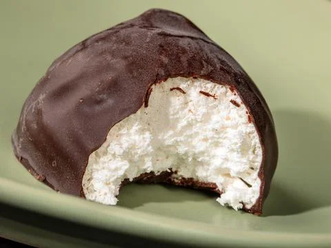 Close-up of bite-sized chocolate marshmallow on a green plate Stock Photos
