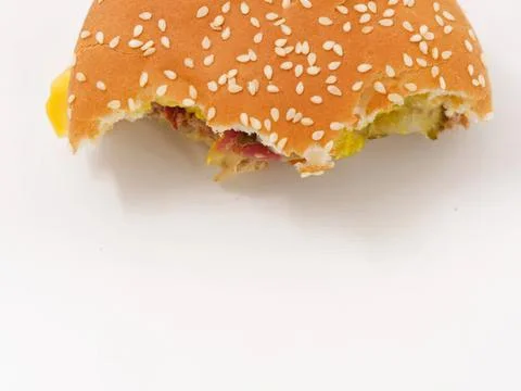 Close-up of bitten cheeseburger with sesame bun and cheese Stock Photos