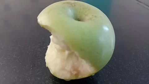 Close-up of a Bitten Granny Smith Apple Isolated on Black Stock Footage 332176589