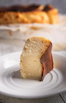 Close-up of bitten portion of basque burnt cheesecake on white plate Stock Photos