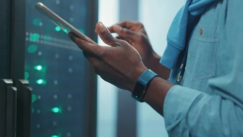 Close-up black african IT engineer using tablet standing at operational server Stock Footage 119783364