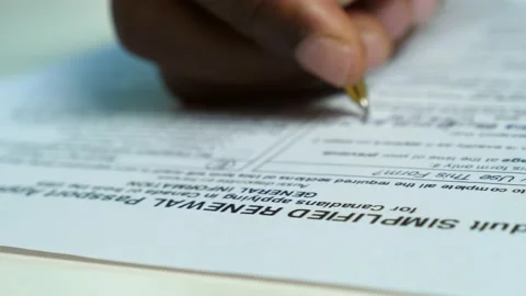 Close up on black african man's hand filling out the passport application form Stock Footage 231480102