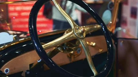 Close-up of black and gold steering wheel inside vintage car showroom Video stock 340880522