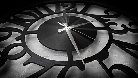 Close up black and white decorative wall clock with metallic hands  Vídeo Stock 337402154