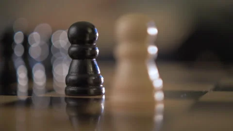 Close up black and white pawn battling on chessboard Stock Footage 145298963