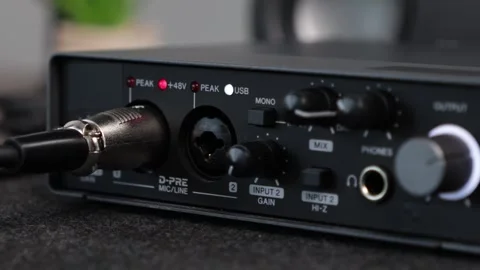 Close-up of a black audio interface with cables and illuminated lights, ess.. Stock Footage 313134219