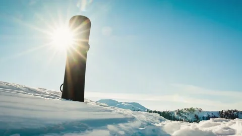 Close up black base of snowboard in snow with white mountains in the backgr.. Stock Footage 232497147