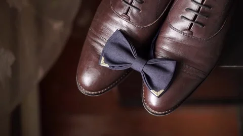 Close-up of black bow tie lying on brown classic, leather shoes. Stock-Footage 200524413