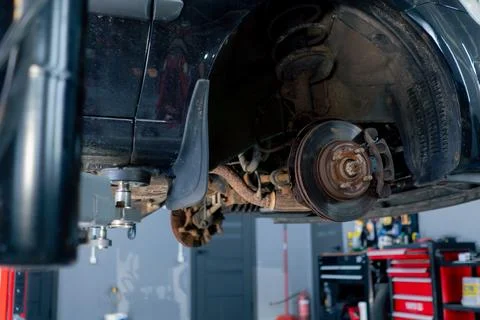 Close-up of a black car without wheels raised at a service station by special Stock Photos