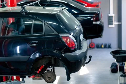 Close-up of a black car without wheels raised at a service station by special Stock Photos