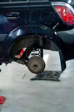 Close-up of a black car without wheels raised at a service station by special Stock Photos