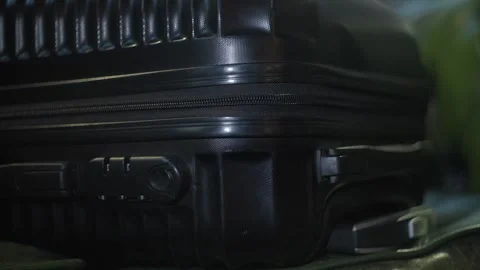 Close-up of a black carry-on suitcase with a passcode lock being zipped Stock Footage 304971397