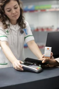 Close up of black client pays using contactless phone technology on a POS Stock Photos