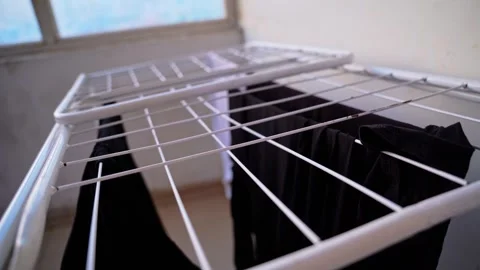 Close up black clothes on indoor drying rack Stock Footage 336763897