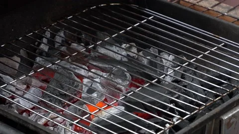 Close-up of black coals heating up with fire on a grill for cooking rooftop meat Stock Footage 160088115