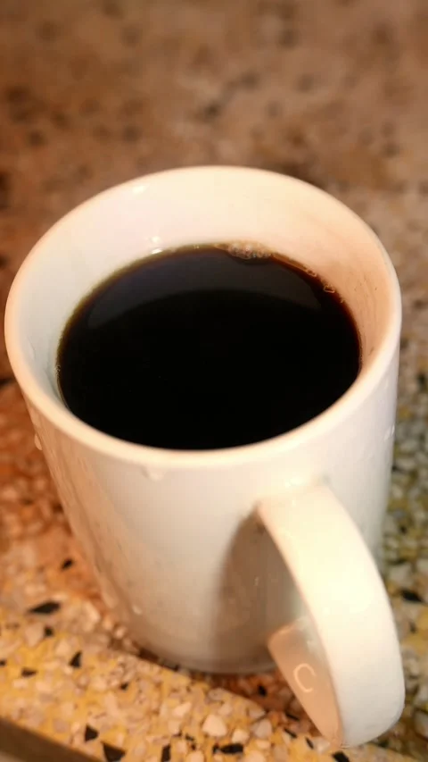 Close-up: black coffee cup on the table. Hot steam rises from the cup of coffee Stock Footage 341904587