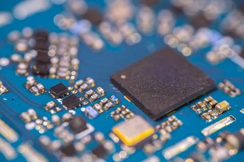 Close up of black computer chip on blue circuit board with electronic compo.. Stock Photos