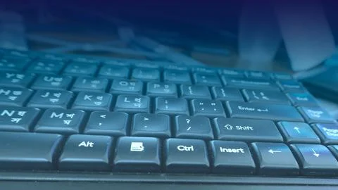 Close-up of a black computer keyboard with a blue light overlay technology .. Ilustración de archivo