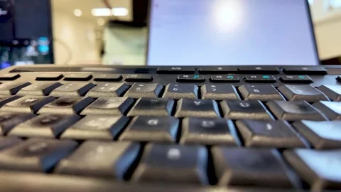 Close Up of Black Computer Keyboard with Laptop Screen in Background for Video stock 327788130
