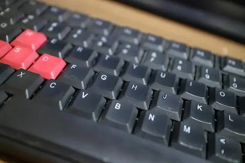 Close-up of black computer keyboard with red keys Фото