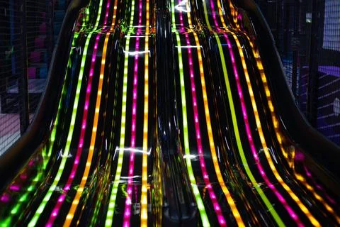 Close up of black dynamic slide with neon led lighting in modern children's e Stock Photos
