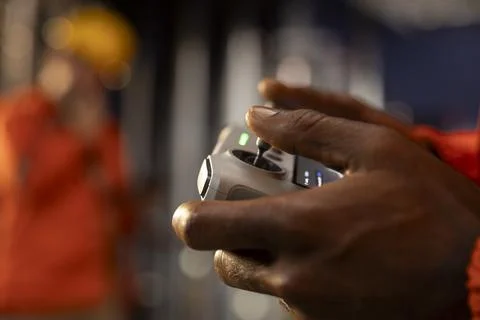 Close up of black employee using drone to collect data from offshore platform Stock Photos