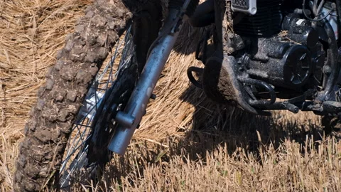 Close up of a black enduro motorcycle in front of a yellow haystack Stock Footage 220150726