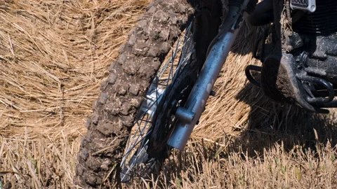 Close up of a black enduro motorcycle in front of a yellow haystack Stock Footage 220150909